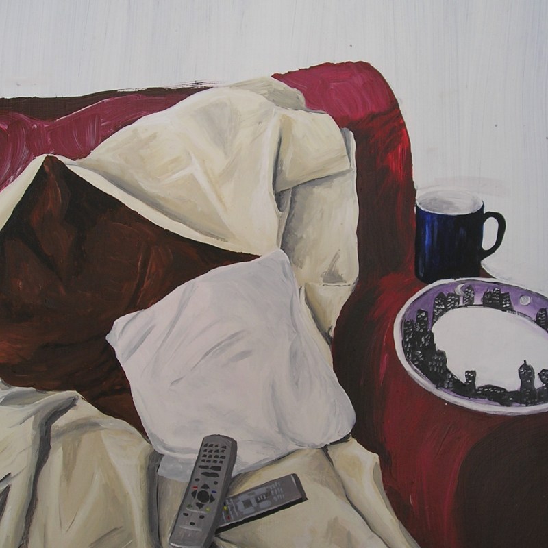 acrylic painting on sofa, blanket, tv remotes, cup and plate